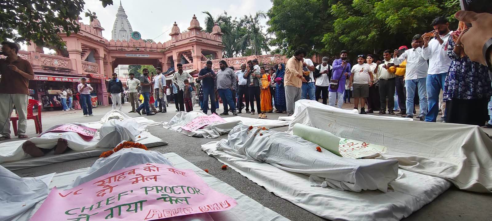 मांगों पर करीब 10 दिनों बाद भी ठोस कार्रवाई नहीं होने का आरोप लगाते हुए कार्यकर्ताओं ने विरोध का अनोखा तरीका अपनाया। पहले विश्वविद्यालय प्रशासन की प्रतीकात्मक शवयात्रा निकालने के बाद अब दर्जनों ABVP कार्यकर्ता काशी विश्वनाथ मंदिर के बाहर शव के प्रतीक के रूप में जमीन पर लेट गए।